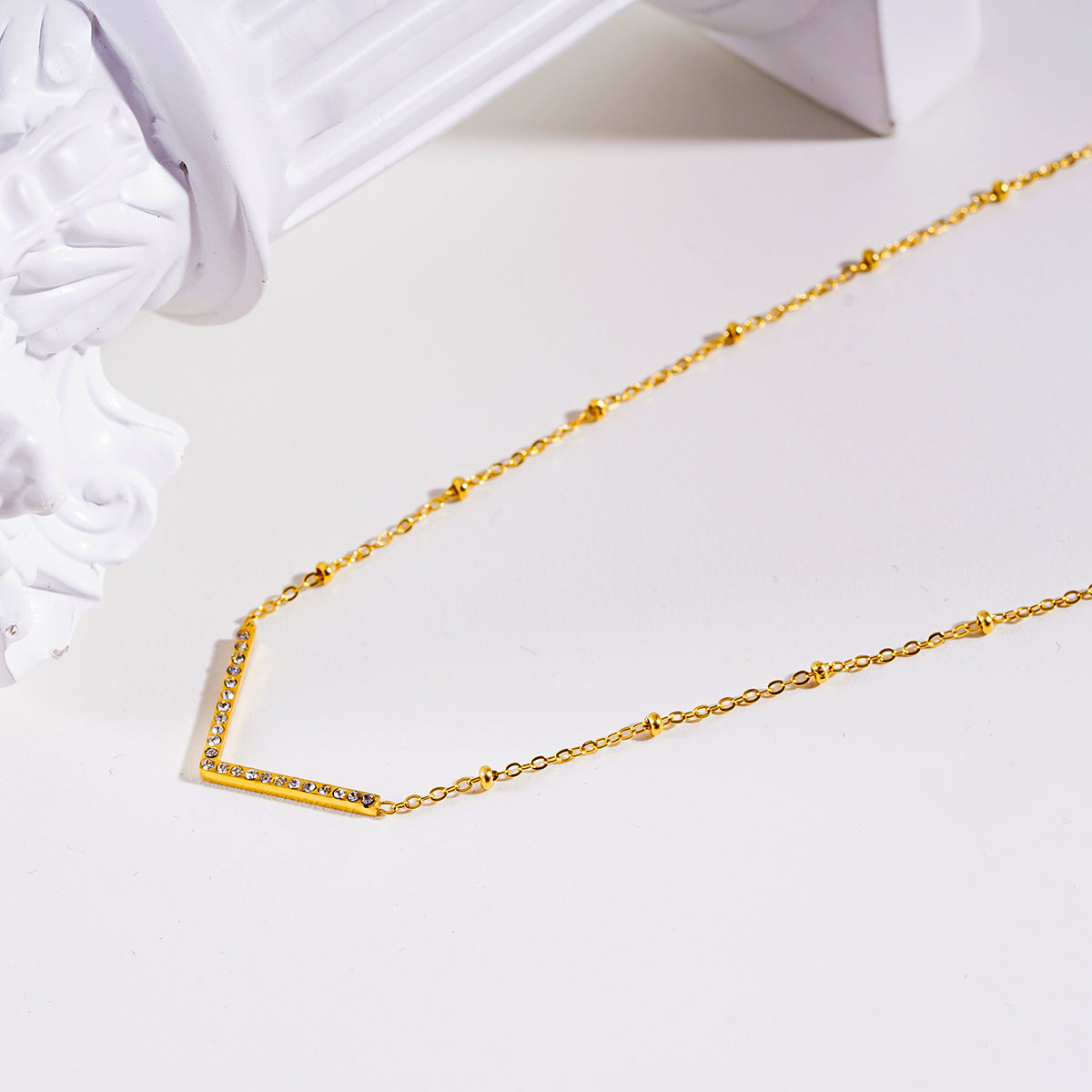 Style SANITA 9712: Beaded Dainty Chain Anchoring 'V' Shaped Zirconia Embedded Pendant Charm.