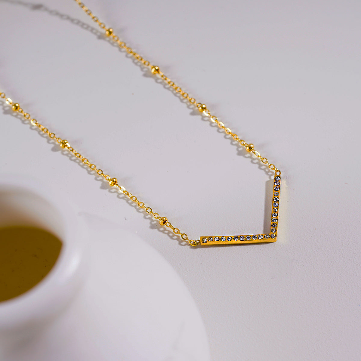 Style SANITA 9712: Beaded Dainty Chain Anchoring 'V' Shaped Zirconia Embedded Pendant Charm.