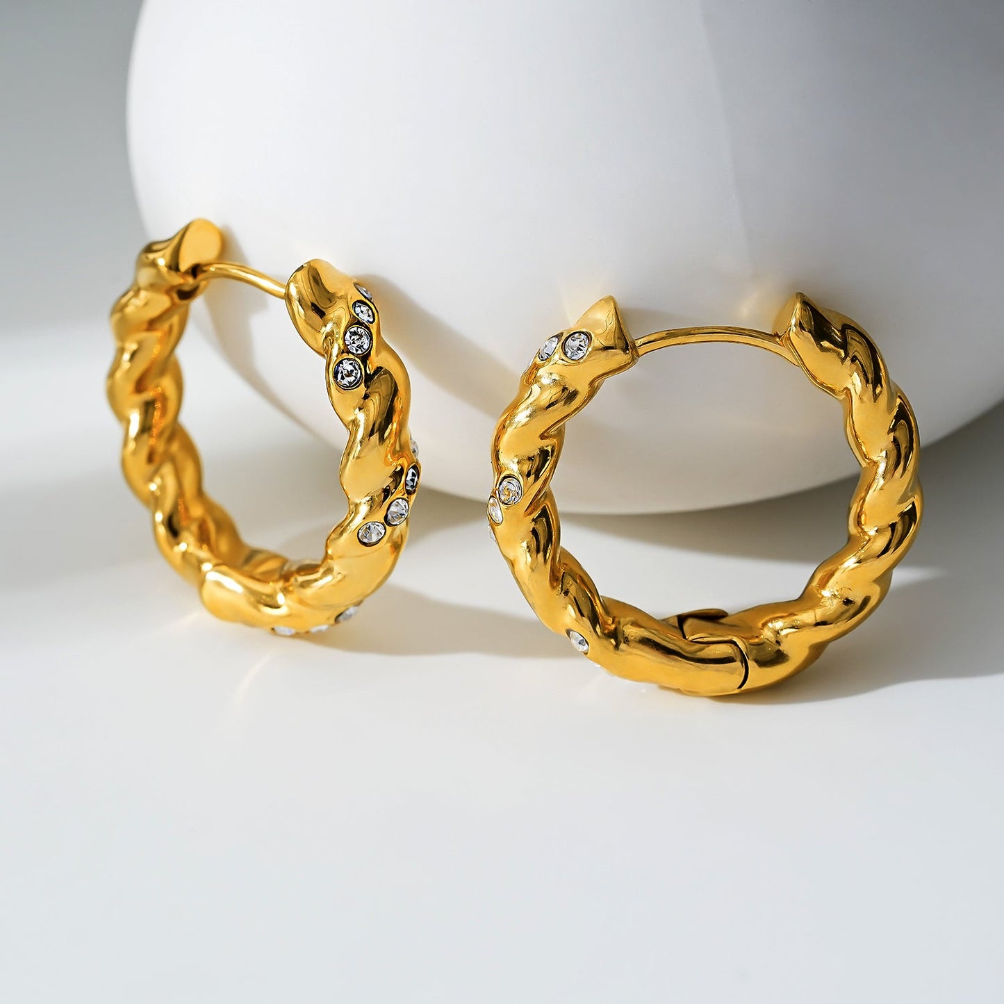 Style KAMENZ 50178: Twisted Textured Hoop Earrings with Zirconia Embellishments.