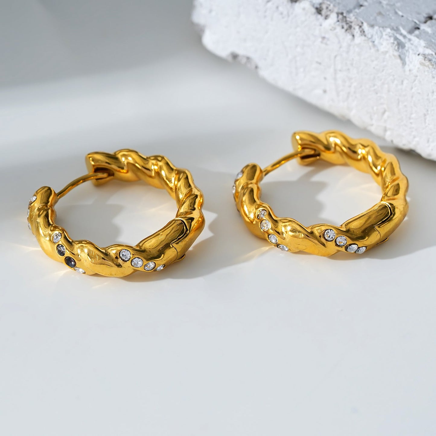 Style KAMENZ 50178: Twisted Textured Hoop Earrings with Zirconia Embellishments.