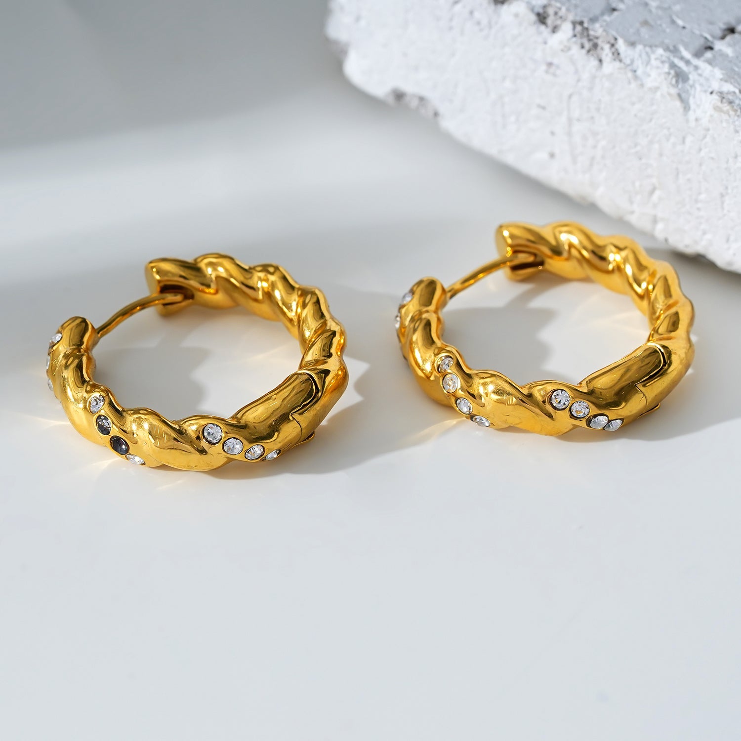 Style KAMENZ 50178: Twisted Textured Hoop Earrings with Zirconia Embellishments.