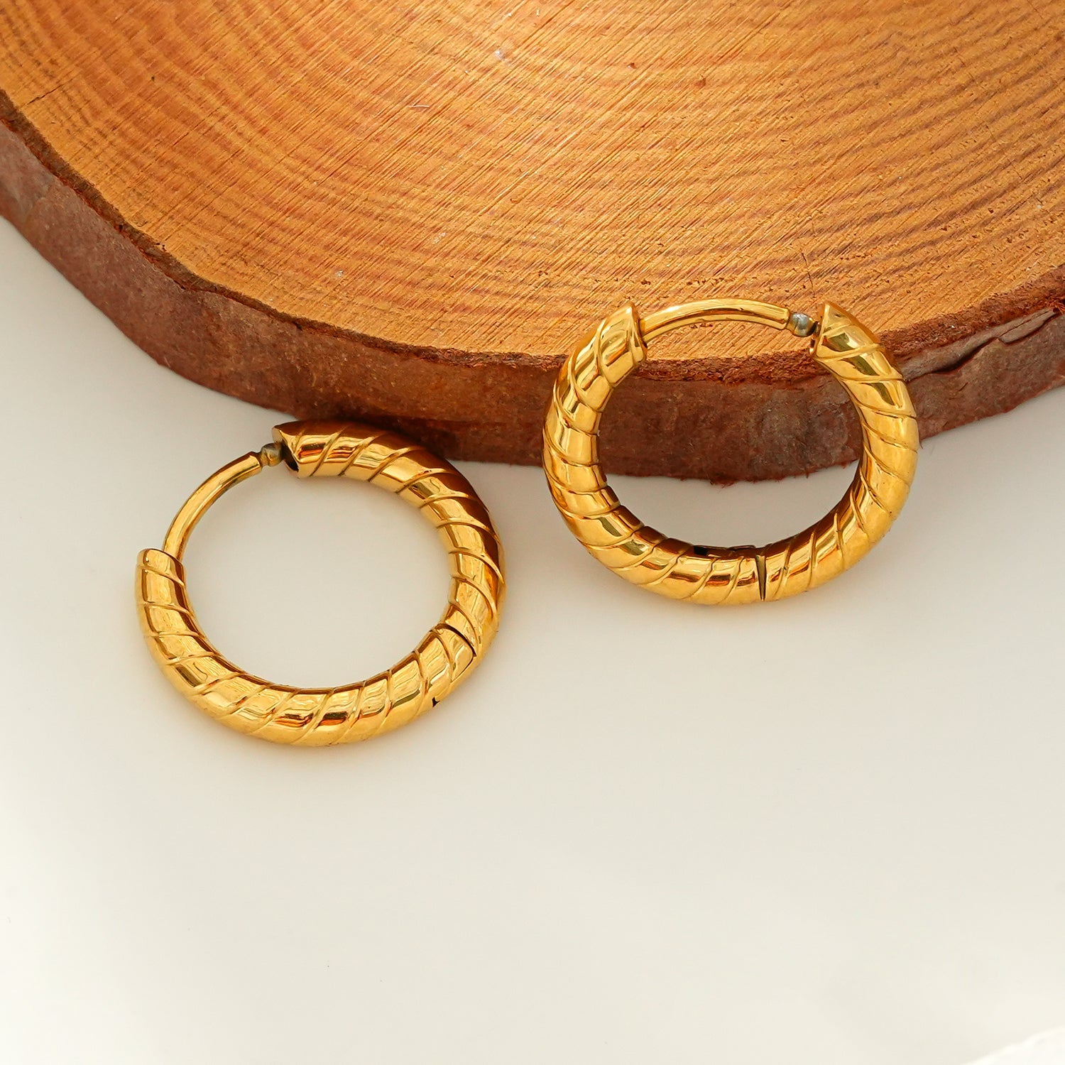 LUPITA: Swirl Design Textured Hoop Earrings in Gold