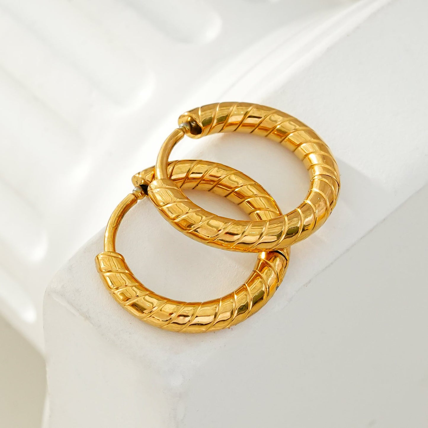 LUPITA: Swirl Design Textured Hoop Earrings in Gold