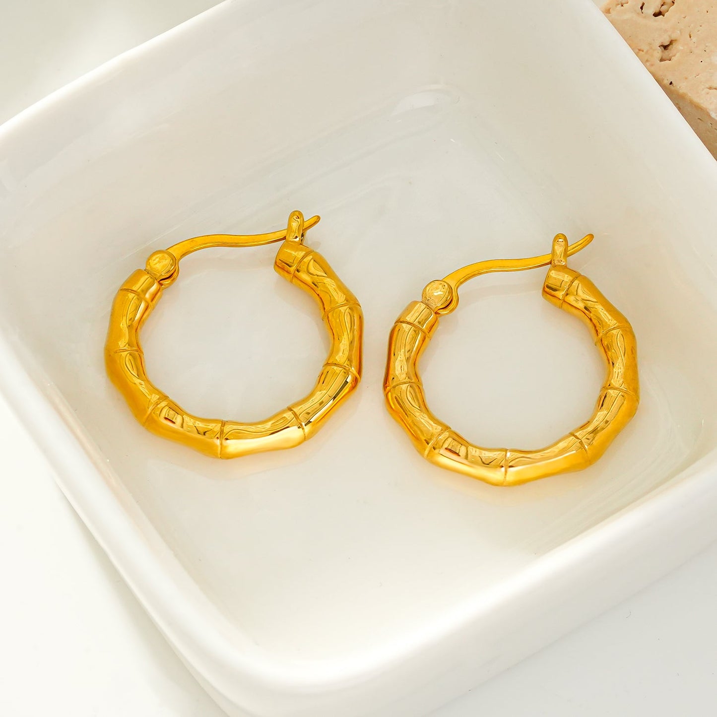 METIOS: Bamboo Textured Hoop Earrings in Gold