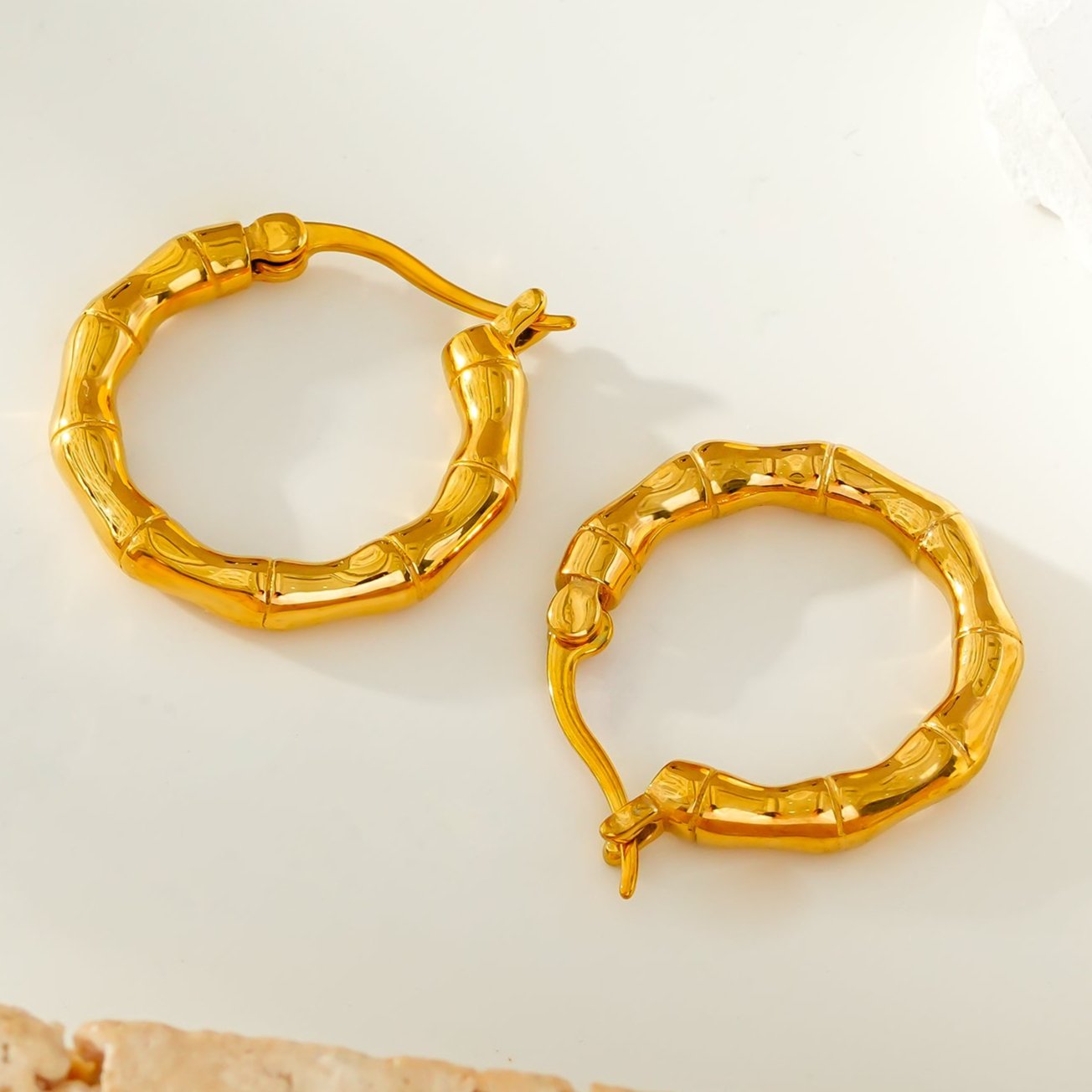 METIOS: Bamboo Textured Hoop Earrings in Gold